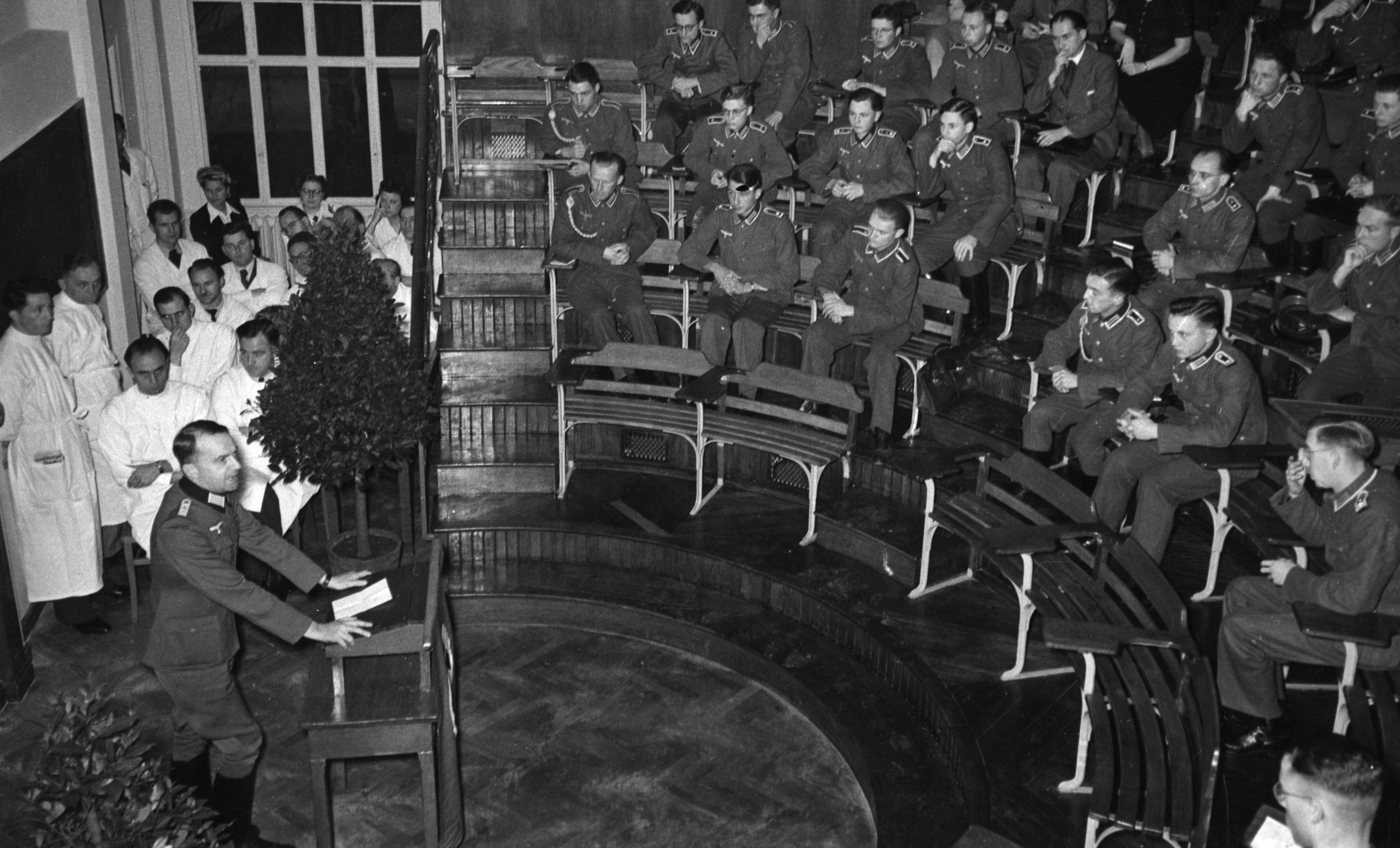 Cours inaugural de la faculté de médecine de la RUS par le doyen Johannes Stein (au pupitre) dans l’amphithéâtre de la clinique médicale B (Medizinische Abteilung I), 24 novembre 1941 © Süddeutsche Zeitung
